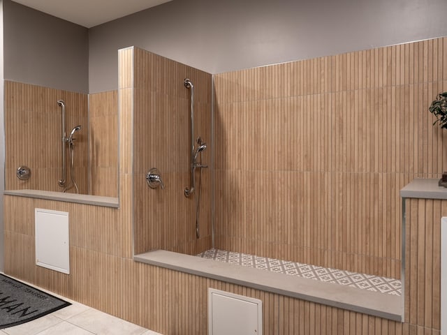 interior space with tiled shower and tile patterned floors