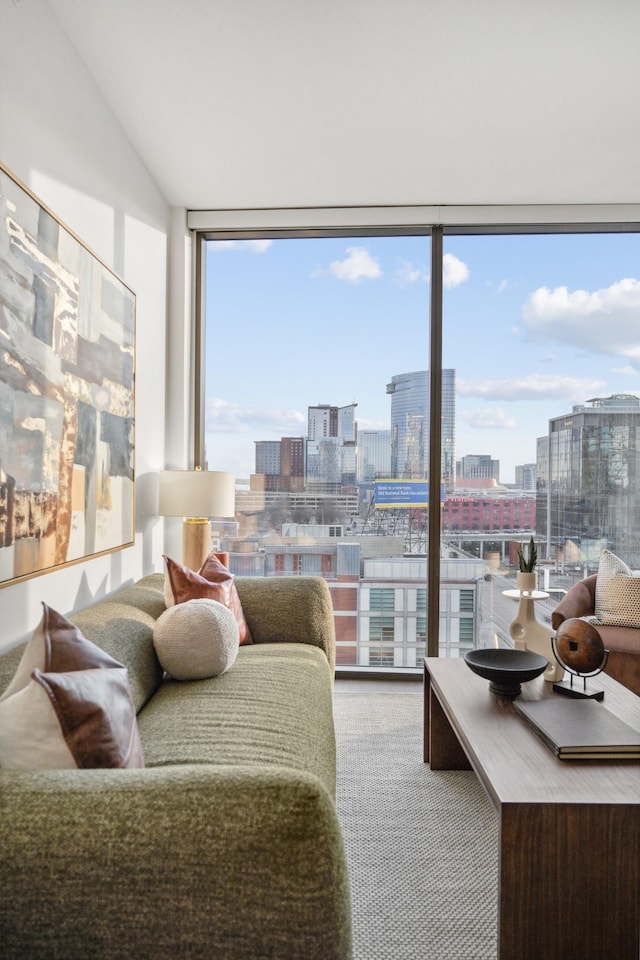 living room with a city view, expansive windows, vaulted ceiling, and carpet floors