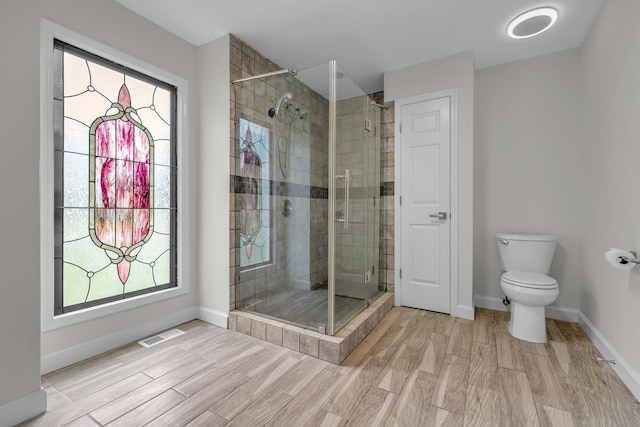4048 Lancashire Dr, Antioch, TN 37013 - full bathroom with a stall shower, toilet, wood finished floors, and baseboards