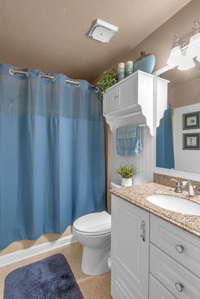 bathroom featuring toilet, vanity, and a textured ceiling