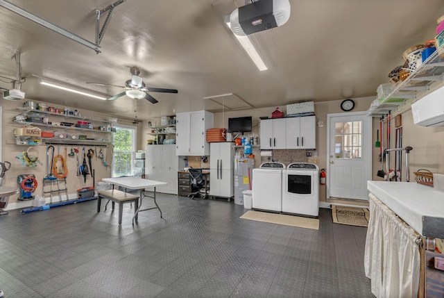 garage featuring independent washer and dryer, a garage door opener, ceiling fan, and a wall unit AC