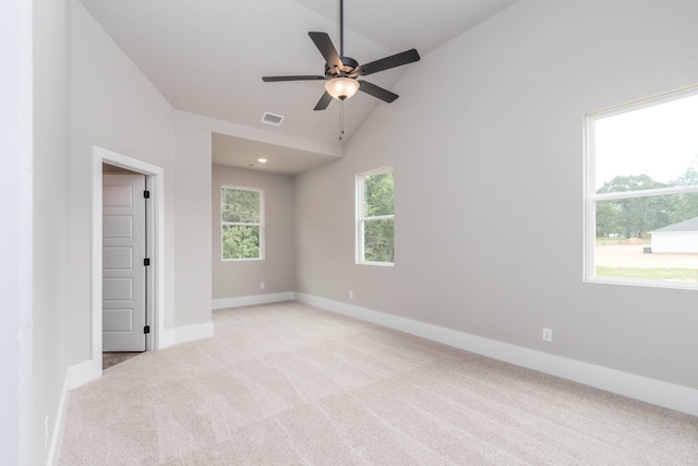 unfurnished room featuring baseboards, ceiling fan, visible vents, high vaulted ceiling, and light carpet