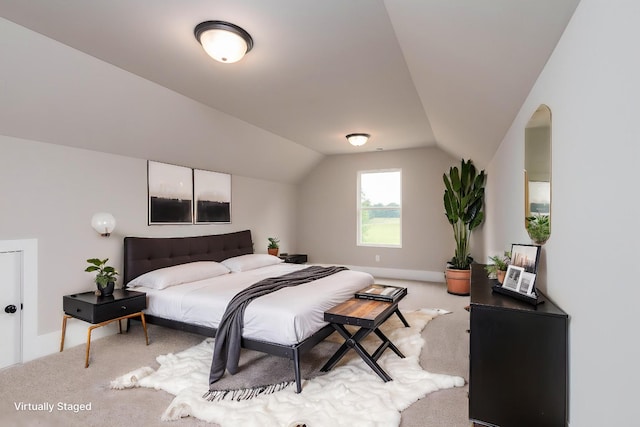bedroom with light carpet, baseboards, and lofted ceiling
