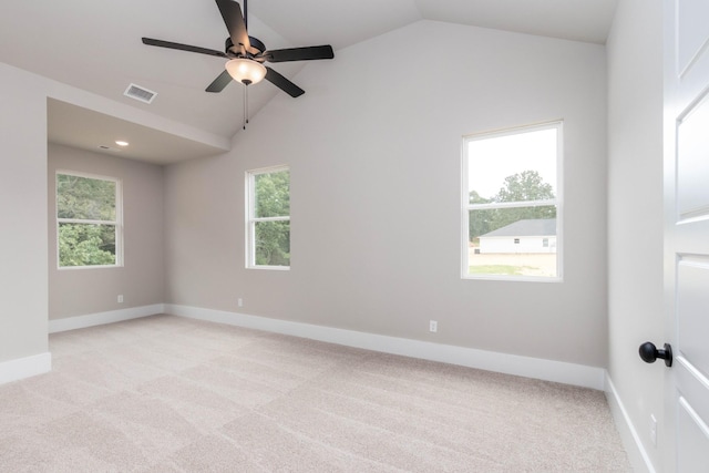 empty room featuring light carpet, a healthy amount of sunlight, visible vents, and vaulted ceiling