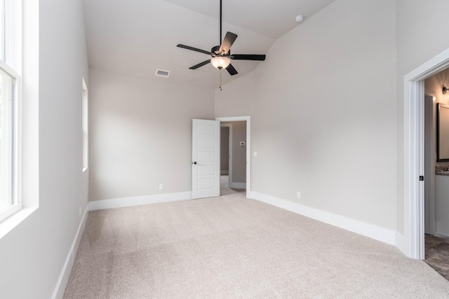 unfurnished bedroom with light carpet, baseboards, high vaulted ceiling, and visible vents