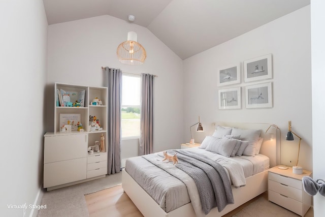 bedroom with light carpet and lofted ceiling