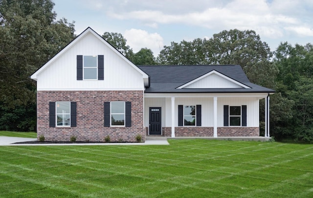 view of front of property with covered porch, brick siding, and a front yard