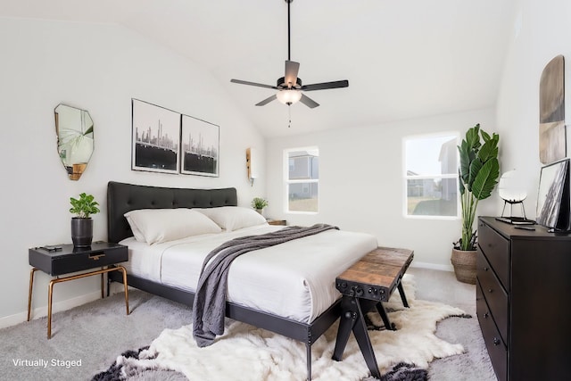 bedroom with baseboards, multiple windows, light colored carpet, and vaulted ceiling