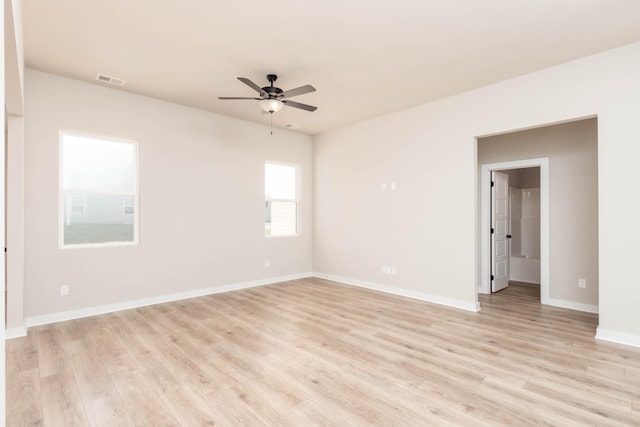 empty room featuring baseboards, light wood finished floors, ceiling fan, and visible vents