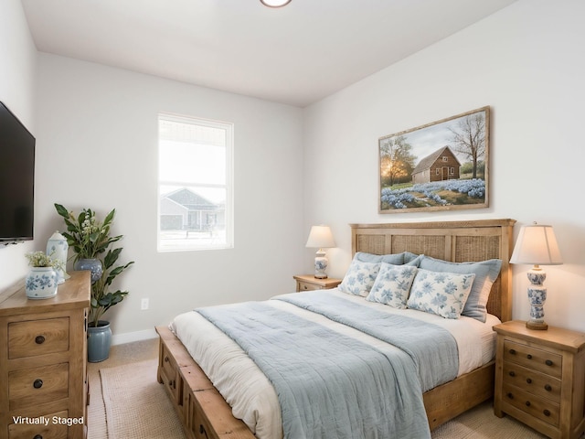 bedroom with baseboards and light colored carpet