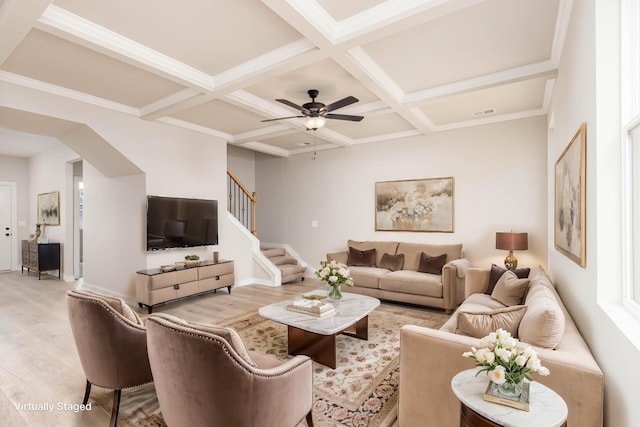 living room with coffered ceiling, ceiling fan, wood finished floors, stairway, and beam ceiling
