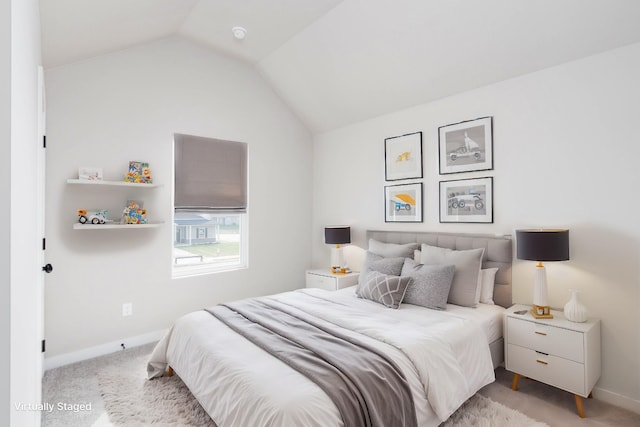 bedroom with vaulted ceiling, light carpet, and baseboards