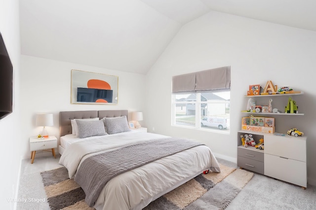 bedroom with light colored carpet and vaulted ceiling