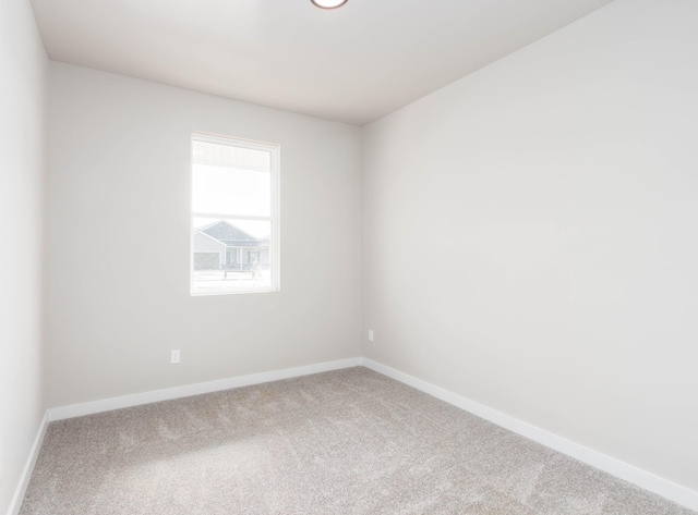 spare room with baseboards and carpet