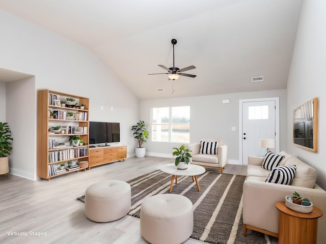 living area featuring vaulted ceiling, ceiling fan, and wood finished floors