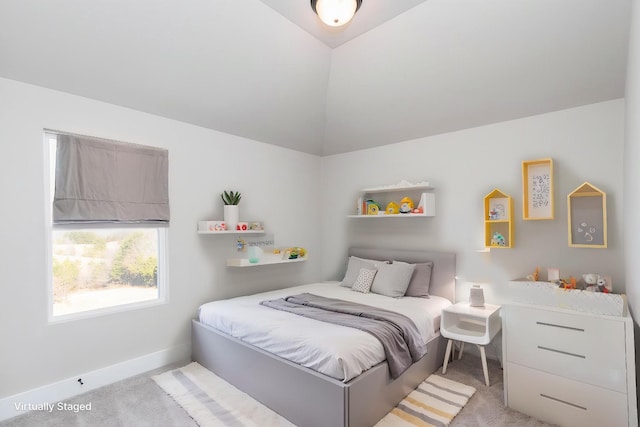 carpeted bedroom featuring baseboards and lofted ceiling