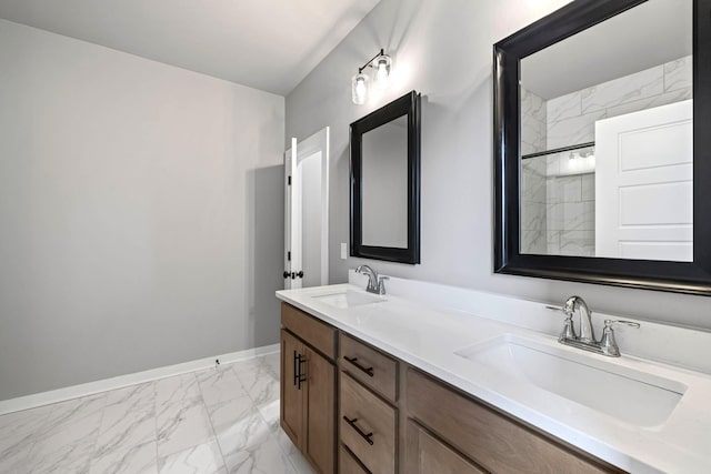 bathroom featuring double vanity, marble finish floor, baseboards, and a sink