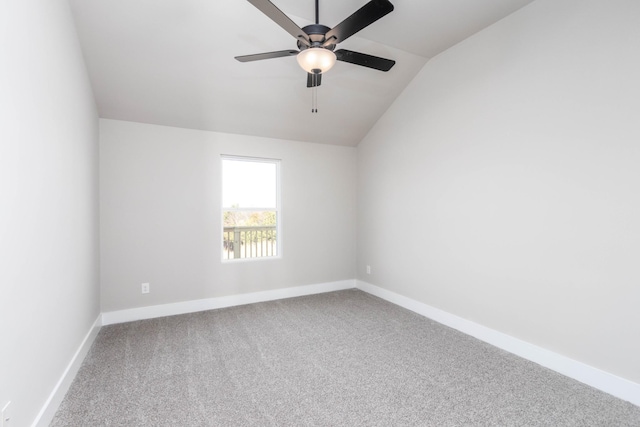 carpeted empty room featuring lofted ceiling, baseboards, and a ceiling fan