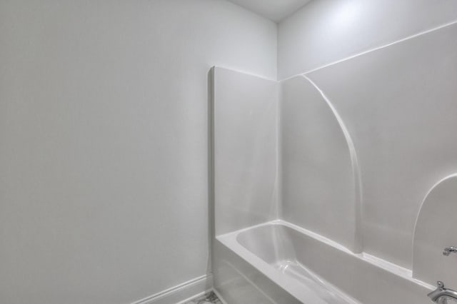 bathroom featuring baseboards and shower / bath combination