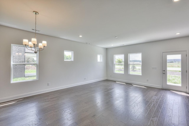 spare room with baseboards, dark wood-style flooring, a notable chandelier, and recessed lighting