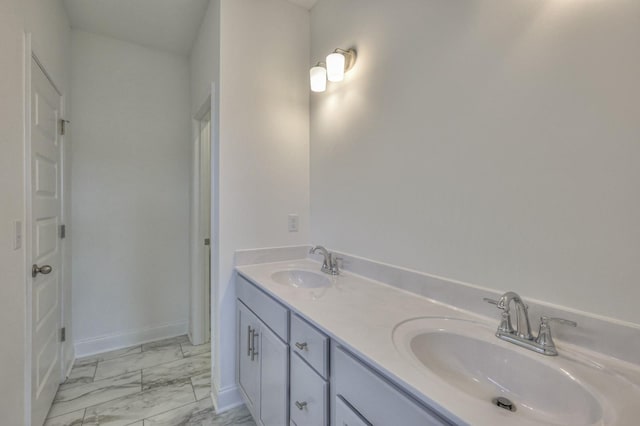 bathroom with a sink, double vanity, baseboards, and marble finish floor