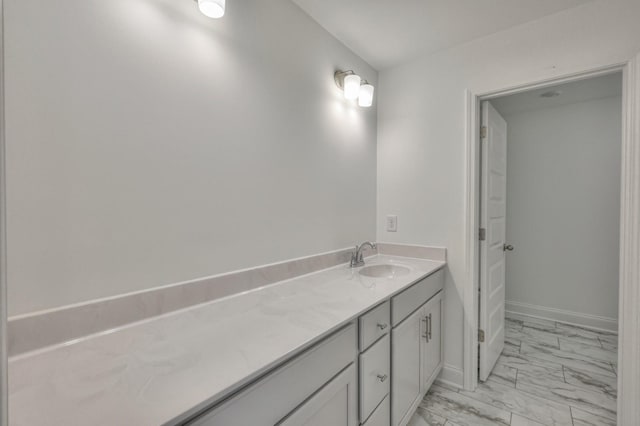 bathroom featuring baseboards, marble finish floor, and vanity