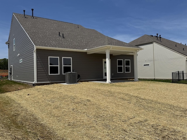 back of house featuring cooling unit and a shingled roof