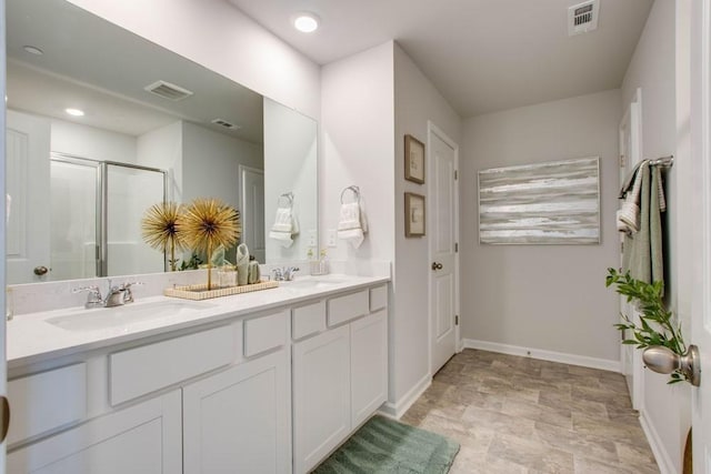 bathroom with a sink, a shower stall, visible vents, and stone finish floor