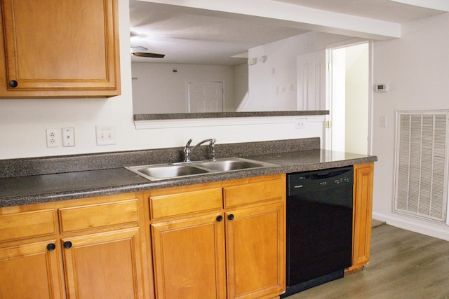 kitchen with a sink, wood finished floors, visible vents, dishwasher, and dark countertops