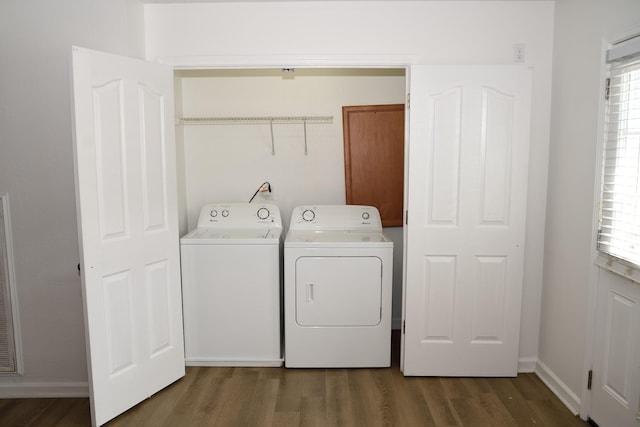 laundry area with baseboards, dark wood finished floors, laundry area, and washer and clothes dryer