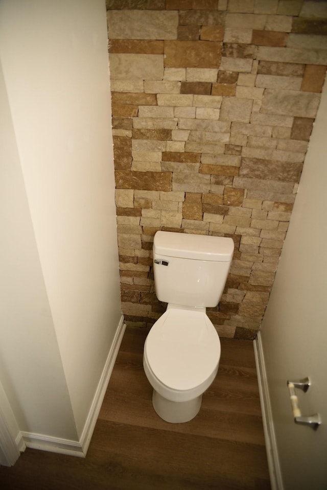 bathroom featuring toilet, baseboards, and wood finished floors