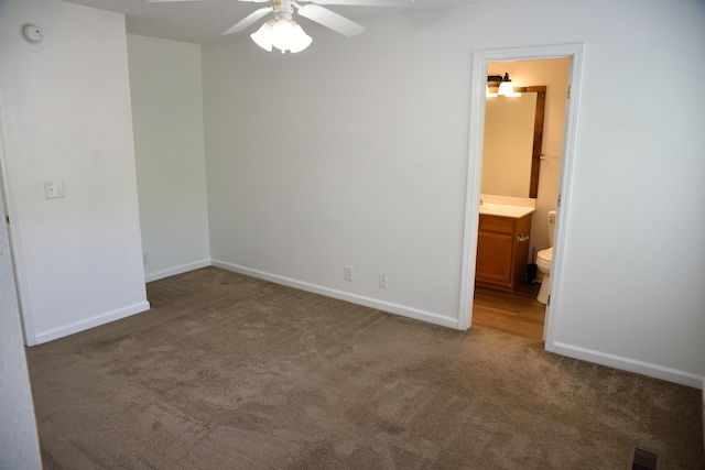 unfurnished bedroom with baseboards, ensuite bathroom, carpet flooring, ceiling fan, and visible vents