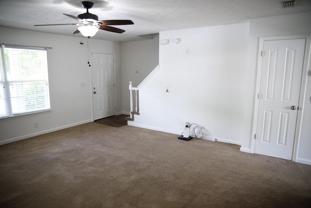 interior space featuring carpet, visible vents, stairway, ceiling fan, and baseboards