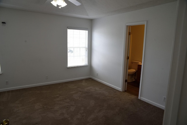 carpeted spare room featuring a ceiling fan and baseboards