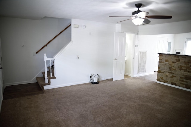 unfurnished living room featuring stairs, visible vents, carpet flooring, a ceiling fan, and baseboards