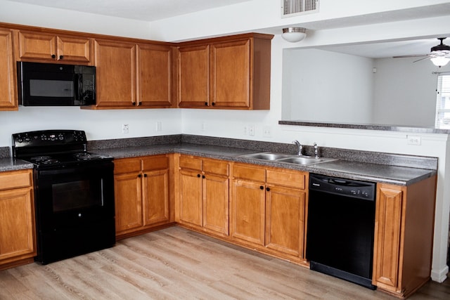 kitchen featuring dark countertops, visible vents, black appliances, and a sink