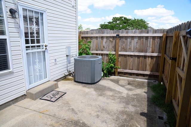 view of patio / terrace with central air condition unit and fence