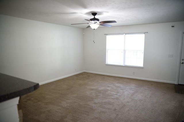 unfurnished room with ceiling fan, carpet floors, and baseboards