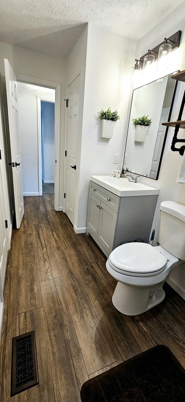 429 E Castle St, Murfreesboro, TN 37130 - bathroom with hardwood / wood-style flooring, toilet, vanity, a textured ceiling, and visible vents