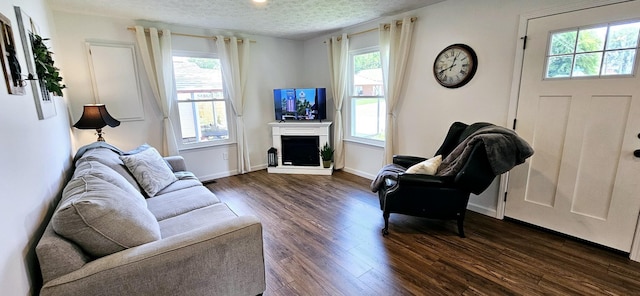429 E Castle St, Murfreesboro, TN 37130 - living area with a textured ceiling, dark wood-type flooring, baseboards, and a fireplace with raised hearth