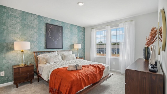 bedroom featuring baseboards, light carpet, and wallpapered walls
