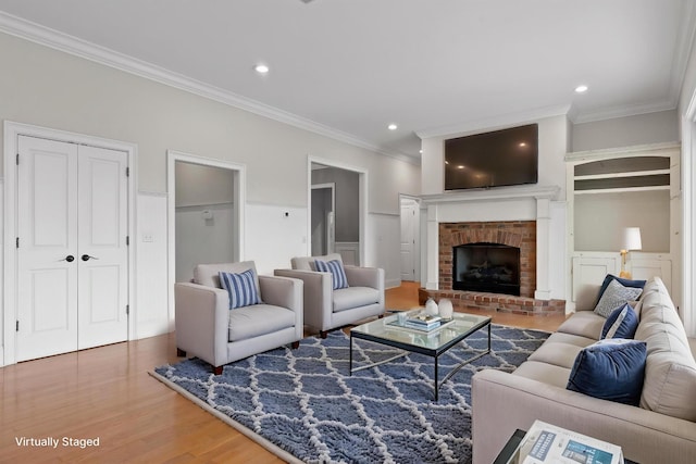 living room with a fireplace, crown molding, recessed lighting, and wood finished floors