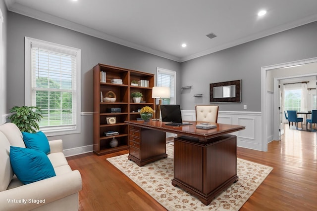 office with ornamental molding, light wood-type flooring, and a healthy amount of sunlight