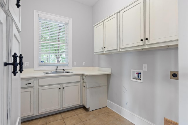 laundry area with light tile patterned floors, a sink, cabinet space, hookup for a washing machine, and baseboards