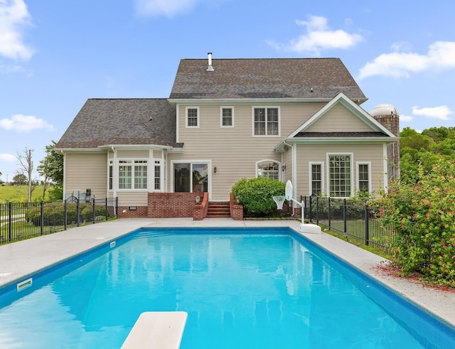 exterior space featuring roof with shingles, fence, and a fenced in pool