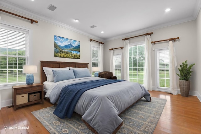 bedroom featuring baseboards, ornamental molding, and light wood finished floors