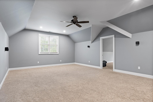 additional living space with light carpet, ceiling fan, and vaulted ceiling