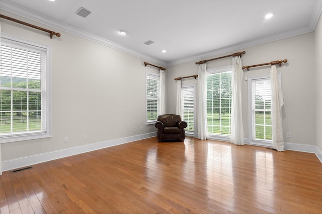 unfurnished room featuring ornamental molding, a wealth of natural light, and hardwood / wood-style floors