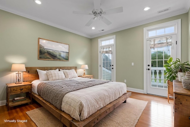 bedroom with visible vents, wood finished floors, and access to exterior