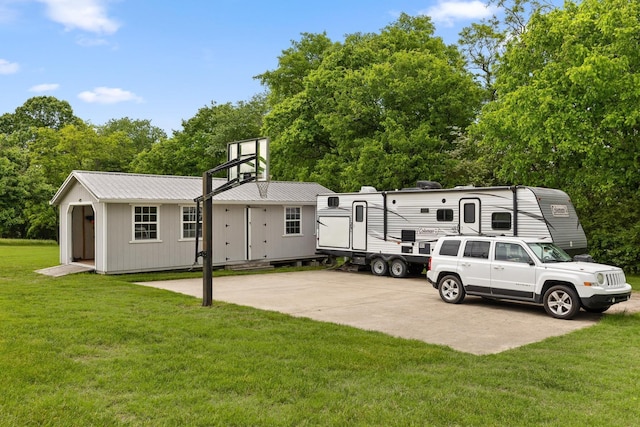 exterior space with a yard, an outdoor structure, and metal roof
